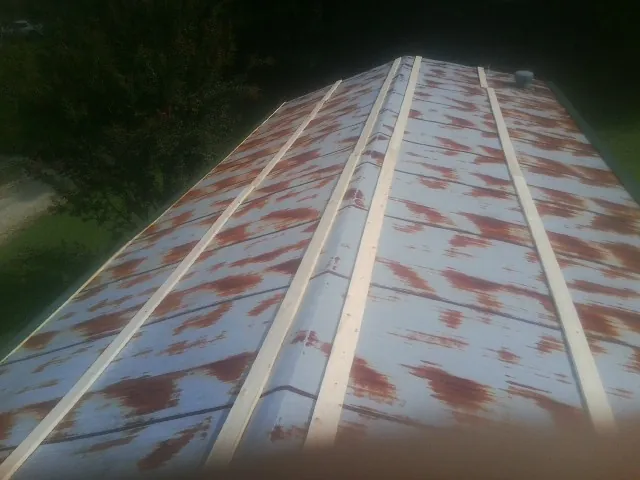 Rusted metal roof panels with new wood purlins before replacement — Storm Damage Roof Repair in Hilham by Roofing Brothers