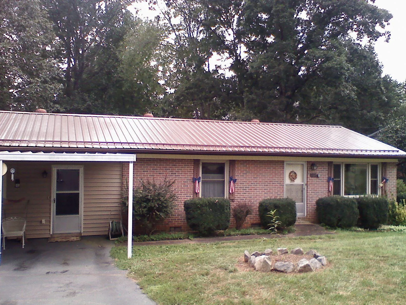 Bronze metal roof and carport on a brick ranch home — Roof Repair work by our crew in Hilham